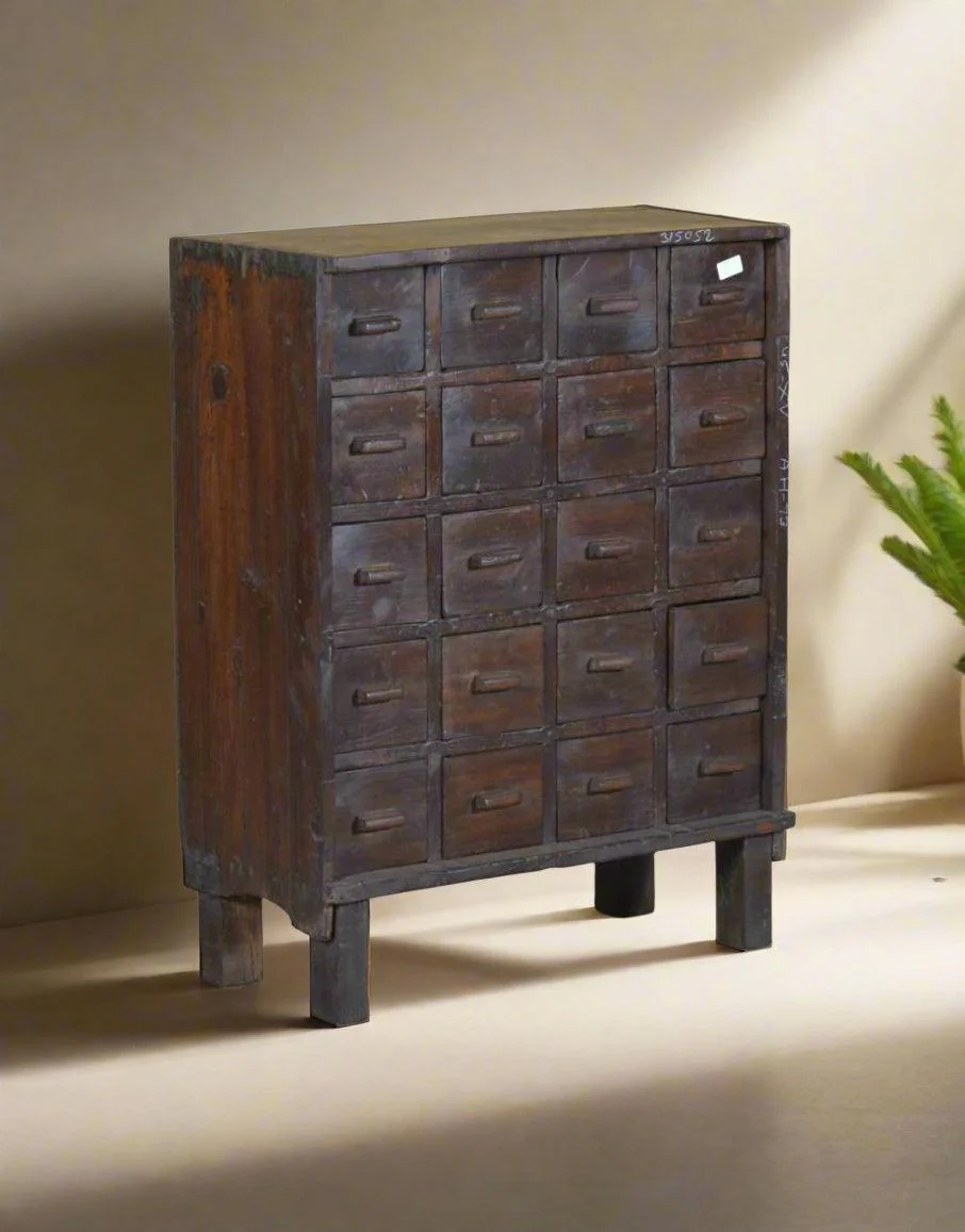 A tall dark wood chest of small drawers after restoration